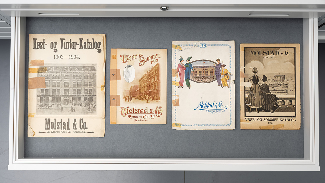 Fire av Molstads produktkataloger, slik de er stilt ut i utstillingen «Å samle på døgnfluer. Inn i motearkivet»